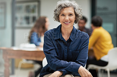 Buy stock photo Portrait of a creative businesswoman sitting in the office while her colleagues work in the background