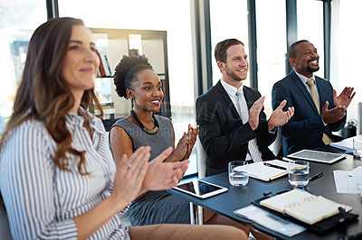 Buy stock photo Shot of a group of corporate businesspeople applauding while sitting in the boardroom