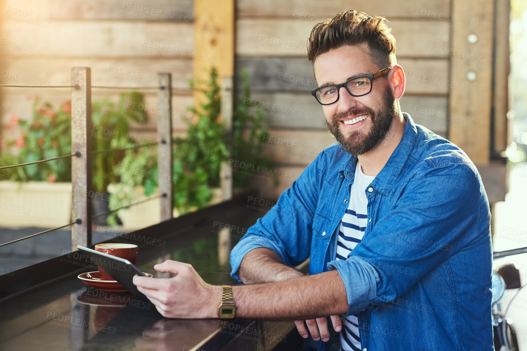 Buy stock photo Portrait of a handsome young man working on a digital tablet in a cafe