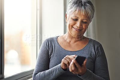 Buy stock photo Window, typing and senior woman with a cellphone, social media and mobile app at home. Mature female, happy model and old lady with a smartphone, email and happiness with network and online reading