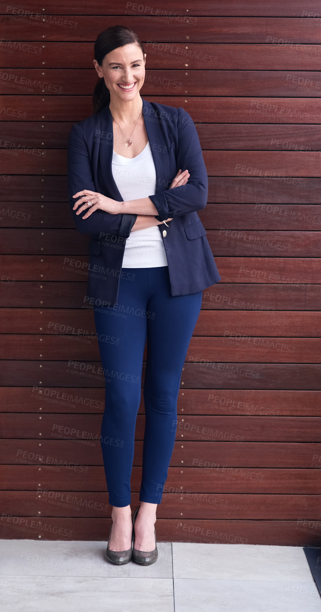 Buy stock photo Portrait of a happy businesswoman standing with her arms folded against a wooden background