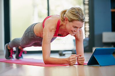 Buy stock photo Shot of a sporty young woman working out at home