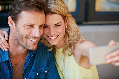 Buy stock photo Shot of a happy couple taking a selfie together on a phone