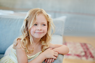 Buy stock photo Shot of a cute little girl looking thoughtful while sitting on the sofa at home