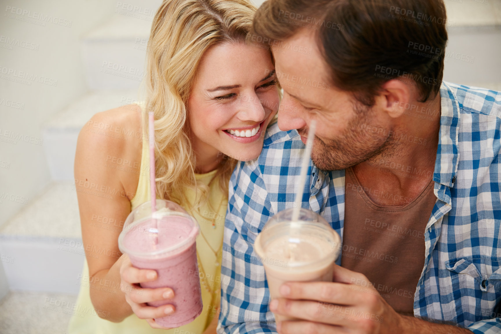 Buy stock photo Shot of a happy couple enjoying refreshing shakes together