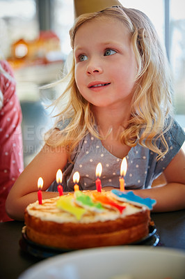 Buy stock photo Cropped shot of an adorable little girl sitting in front of her birthday cake