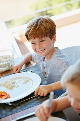Buy stock photo Cropped shot of a little boy enjoying a meal with his family at home