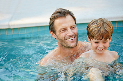 Buy stock photo Cropped shot of a father and son swimming in a pool together