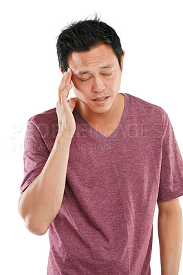 Buy stock photo Studio shot of a young man holding his sore head against a white background