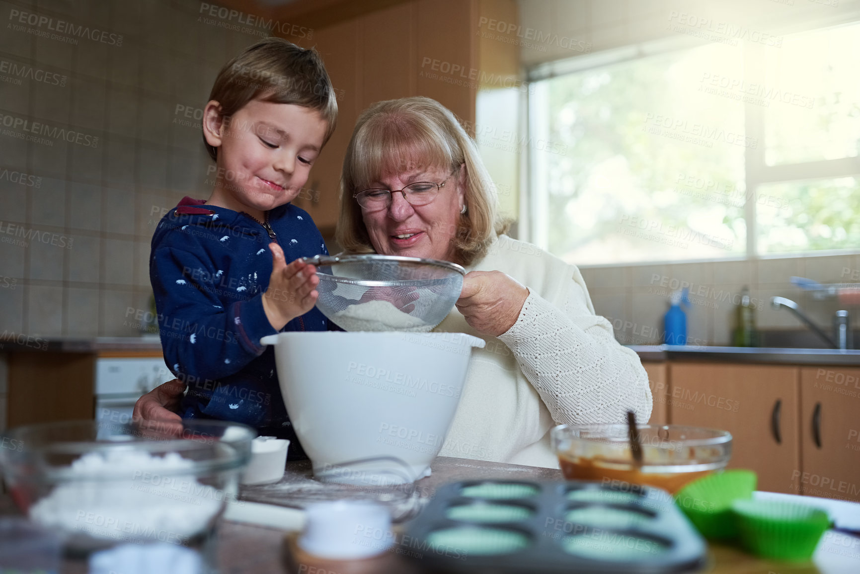 Buy stock photo Cropped shot of a woman baking with her grandson at home