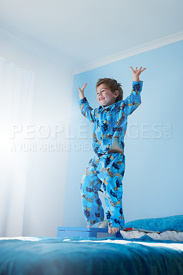 Buy stock photo Shot of a little boy jumping on his bed