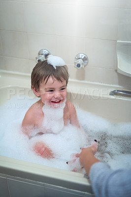 Buy stock photo Cropped shot of a little boy sitting in a bathtub
