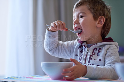 Buy stock photo Cropped shot of a little boy eating breakfast at home