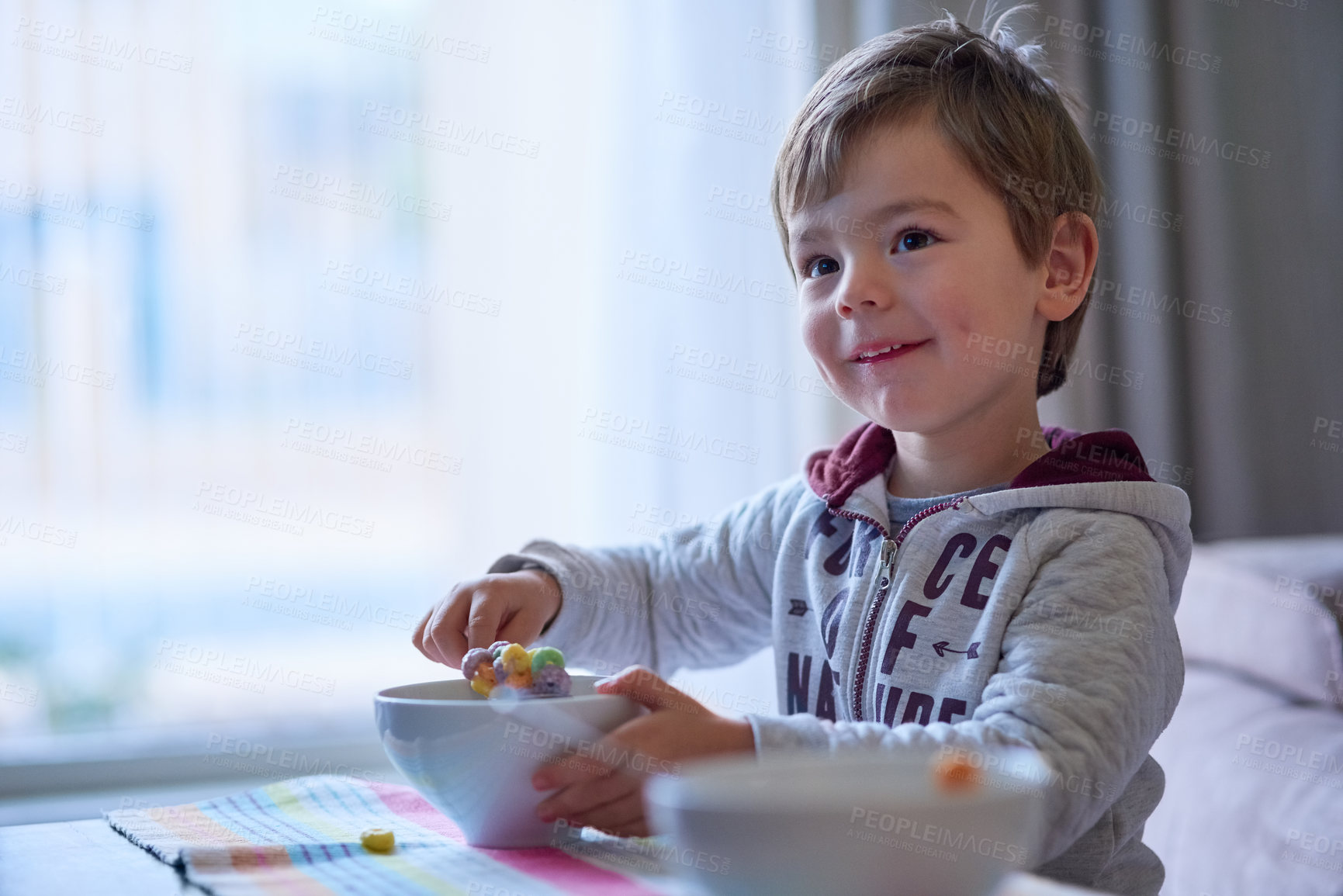 Buy stock photo Cropped shot of a little boy eating breakfast at home