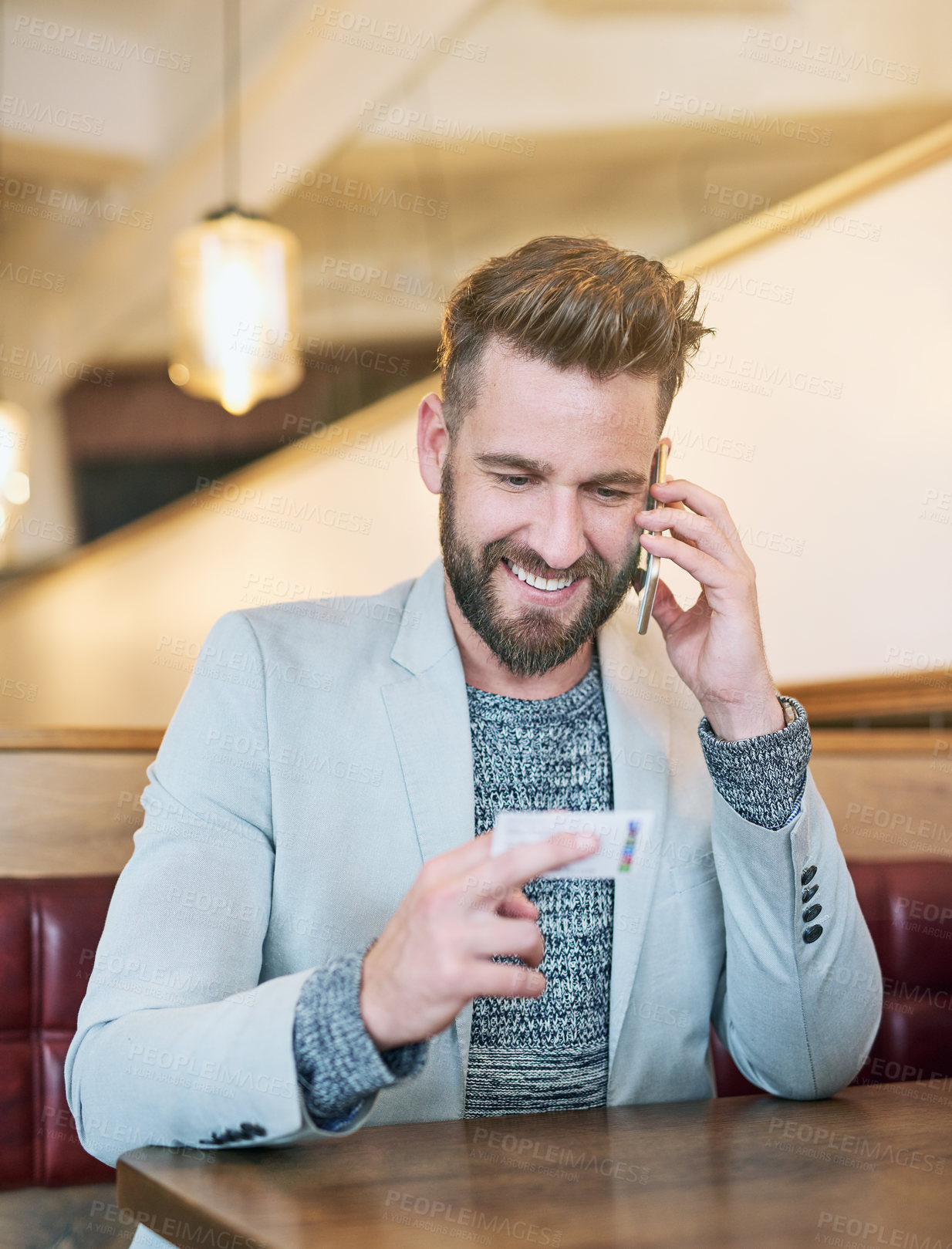 Buy stock photo Cropped shot of a modern businessman using his cellphone in a coffee shop