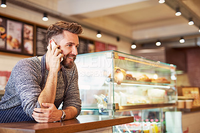 Buy stock photo Cropped shot of a business owner talking on a cellphone in his cafe