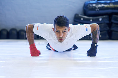 Buy stock photo Portrait of a young man doing pushups in the gym