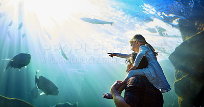 Buy stock photo Cropped shot of a father and his little daughter looking at an exhibit in an aquarium