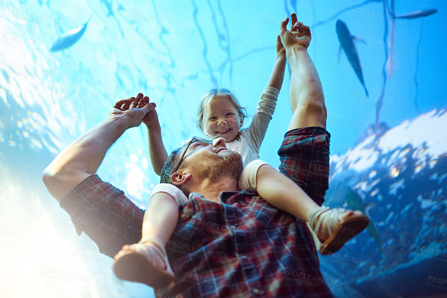 Buy stock photo Cropped shot of a father and his little daughter looking at an exhibit in an aquarium
