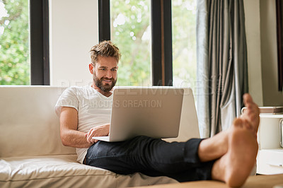 Buy stock photo Shot of a young man using a laptop at home