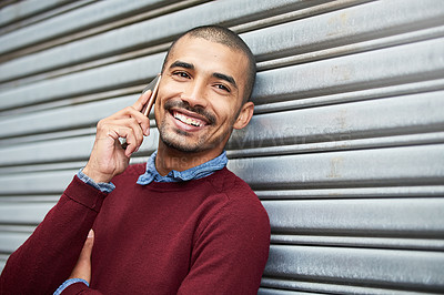 Buy stock photo Cropped shot of a young businessman talking on a cellphone outside