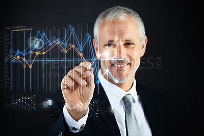 Buy stock photo Shot of a mature businessman working with a digital interface against a black background