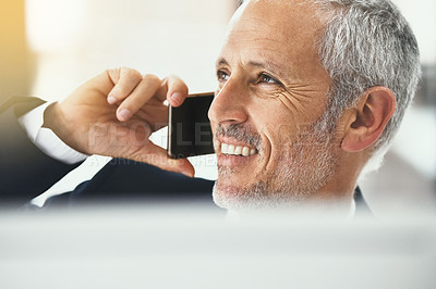 Buy stock photo Shot of a smiling mature businessman talking on the phone while working in an office