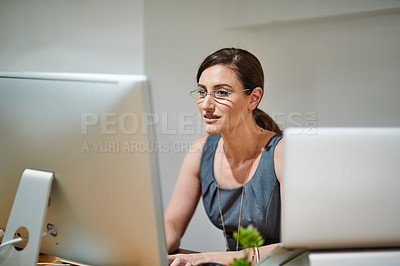 Buy stock photo Shot of a professional businesswoman using a computer at her office desk
