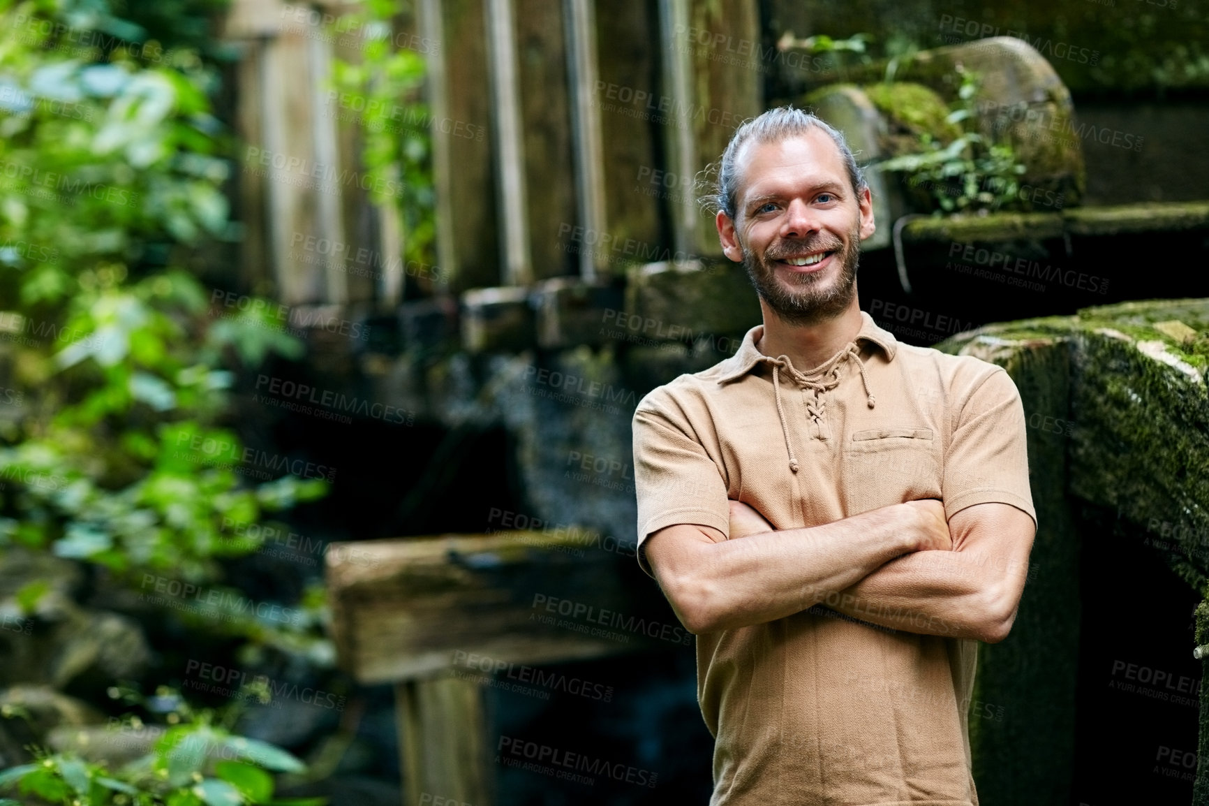 Buy stock photo Portrait of a handsome man standing with his arms folded outdoors