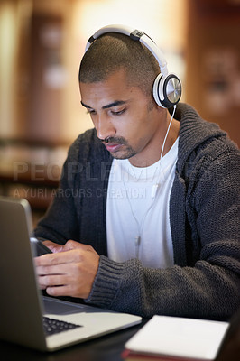 Buy stock photo Cropped shot of a college student texting on his cellphone while working at campus