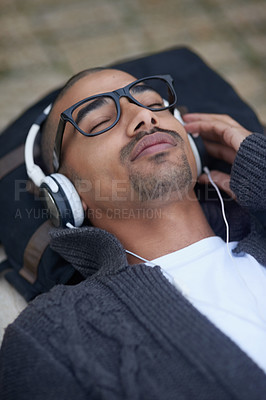 Buy stock photo Cropped shot of a college student listening to music on headphones at campus