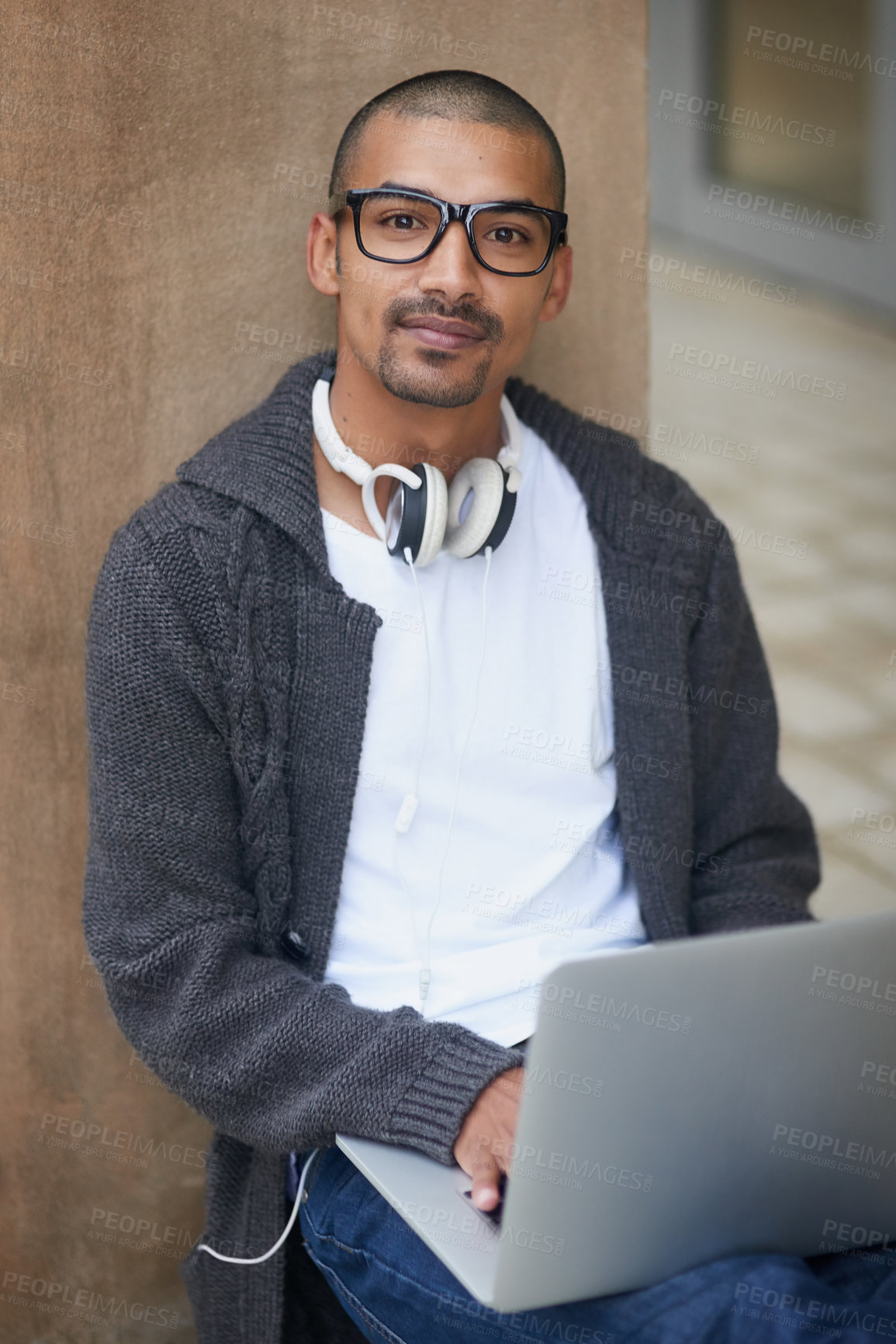 Buy stock photo Portrait of a college student using his laptop while sitting outside at campus