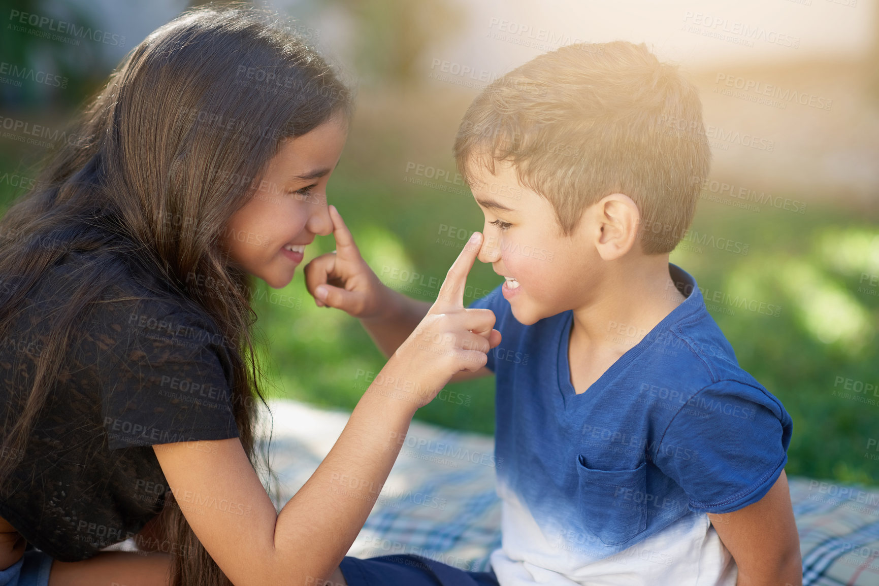 Buy stock photo Shot of a young brother and sister touching each other's noses while playing outside their home