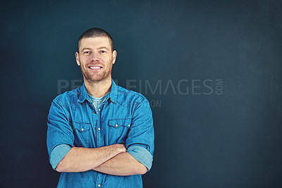 Buy stock photo Portrait of a confident young businessman standing with his arms folded in the studio