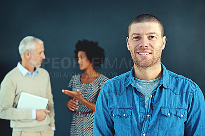 Buy stock photo Studio portrait of a young businessman posing with his colleagues in the background