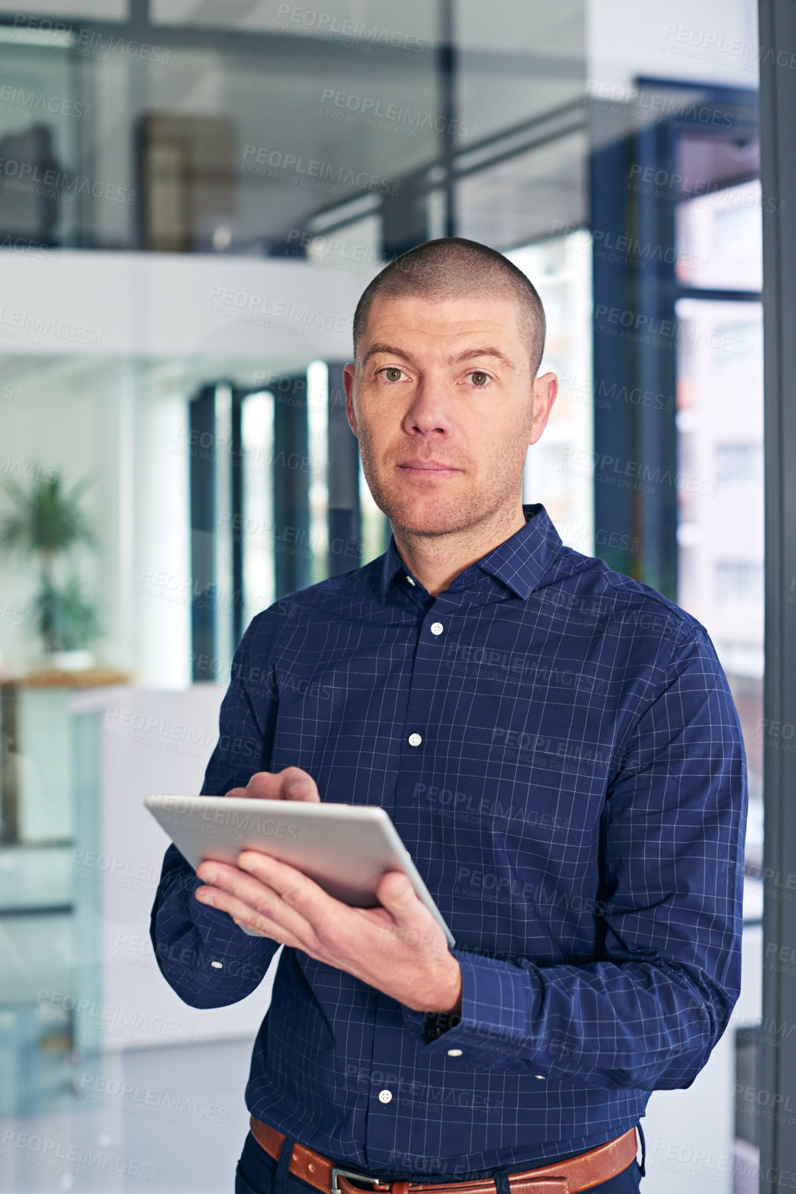 Buy stock photo Portrait of a businessman using a digital tablet in a modern office