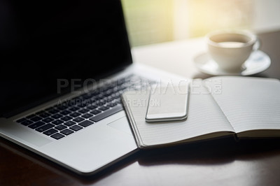 Buy stock photo High angle shot of a laptop, cellphone and notebook on a  table