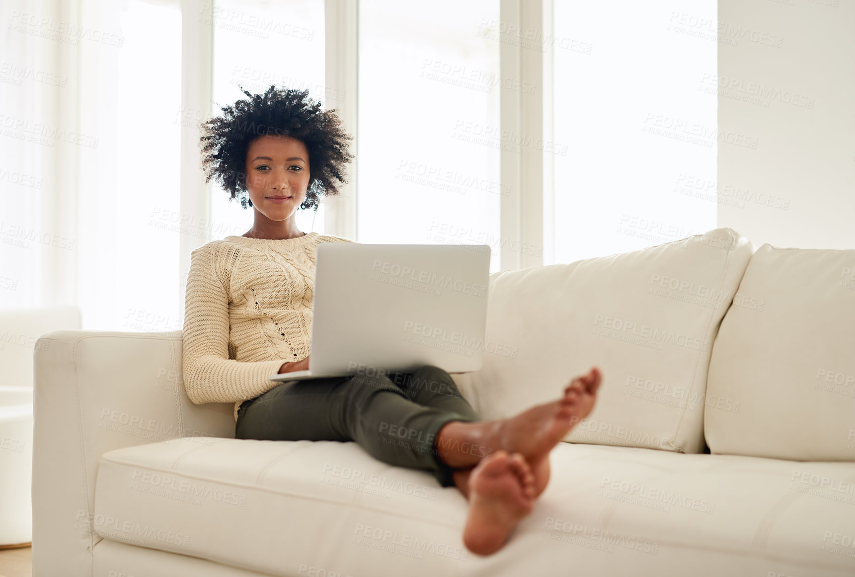 Buy stock photo Portrait of an attractive young using her laptop while sitting on the sofa at home