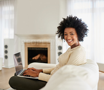 Buy stock photo Portrait of an attractive young using her laptop while sitting on the sofa at home