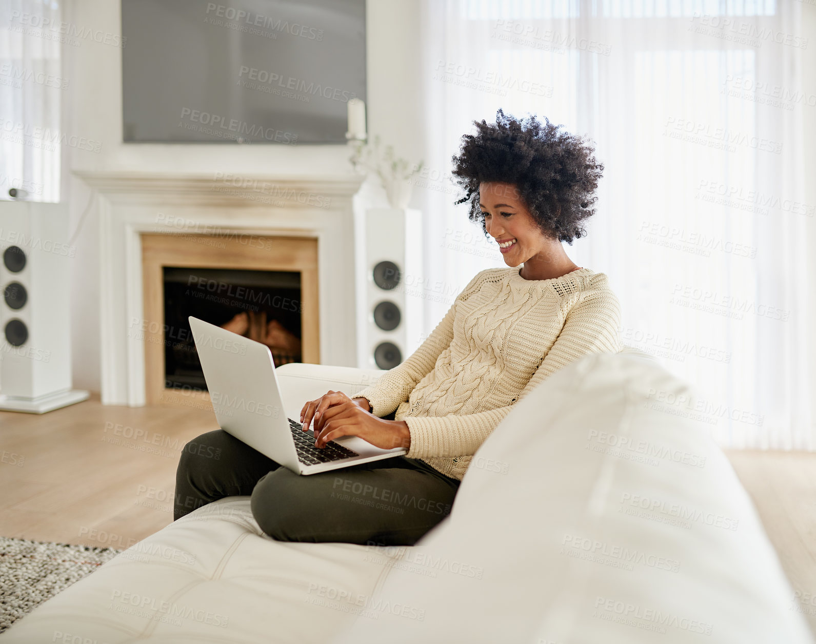 Buy stock photo Shot of an attractive young using her laptop while sitting on the sofa at home