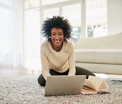 Buy stock photo Portrait of an attractive young using her laptop and reading a book whille sitting on the floor at home