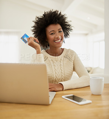 Buy stock photo Portrait of an attractive young woman shopping online using her laptop while sitting on the sofa at home