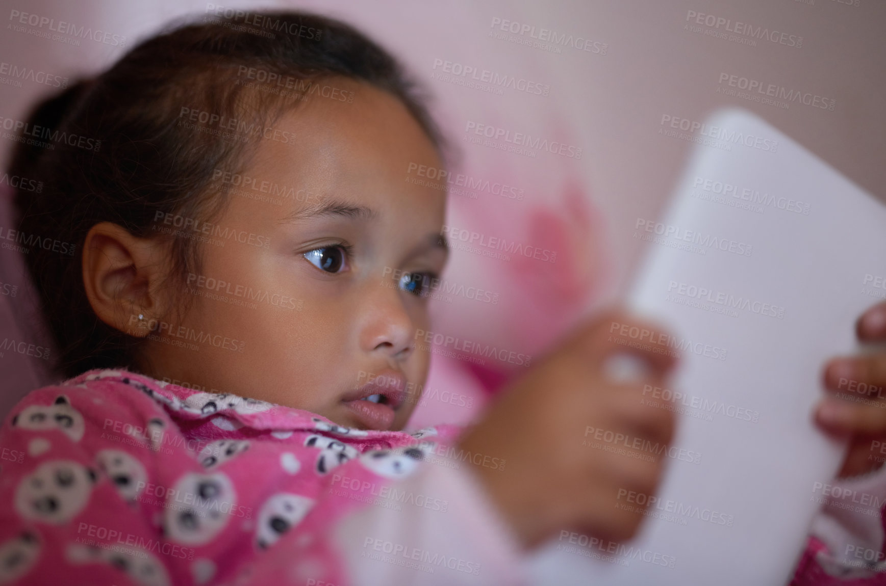 Buy stock photo Shot of a little girl lying in bed using a digital tablet