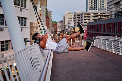 Buy stock photo Shot of a young man exercising outdoors on a bridge