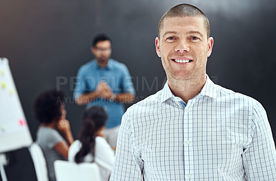 Buy stock photo Portrait of a businessman standing in the boardroom while a colleague gives a presentation in the background