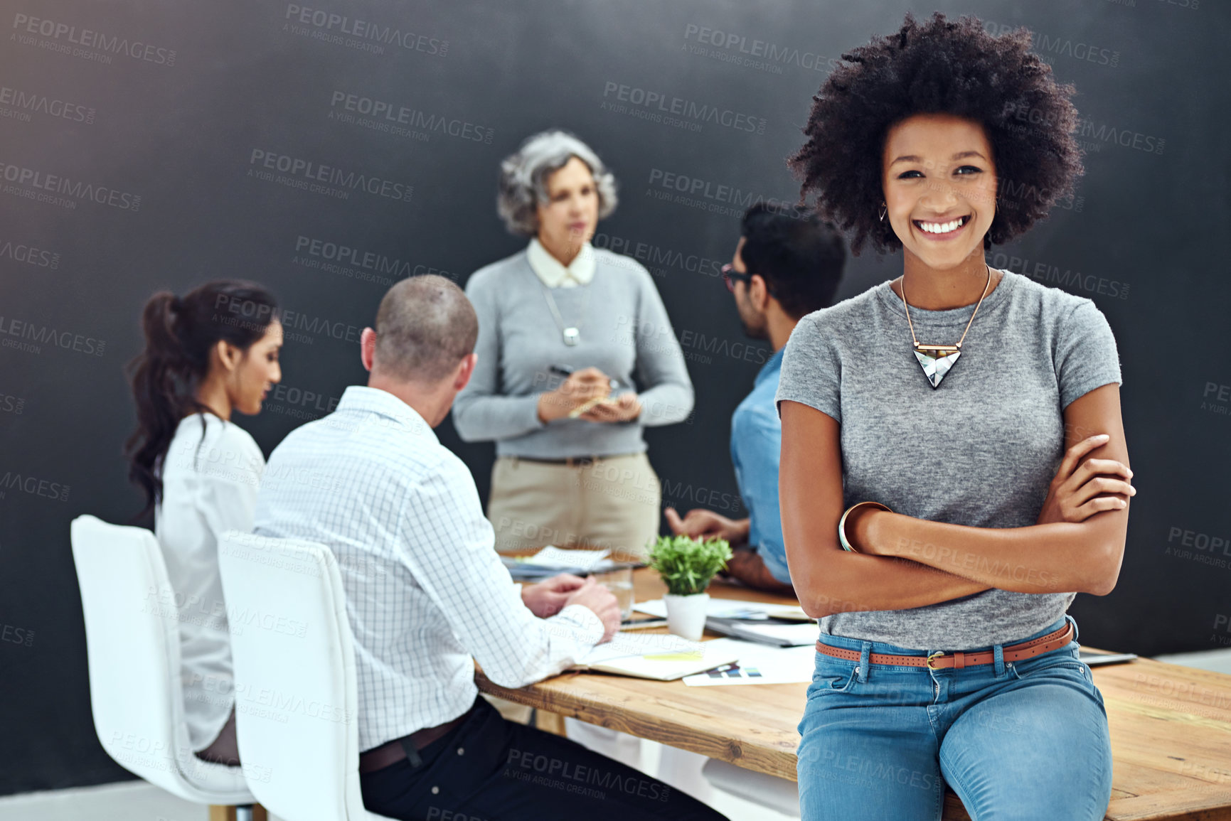 Buy stock photo Portrait of a businesswoman standing with her arms folded in the boardroom while a colleague gives a presentation in the background