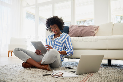 Buy stock photo Shot of a young woman working on her digital tablet and laptop at home