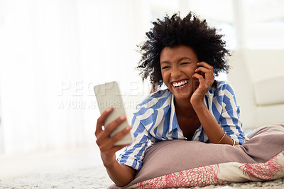 Buy stock photo Shot of a young woman texting on her cellphone at home