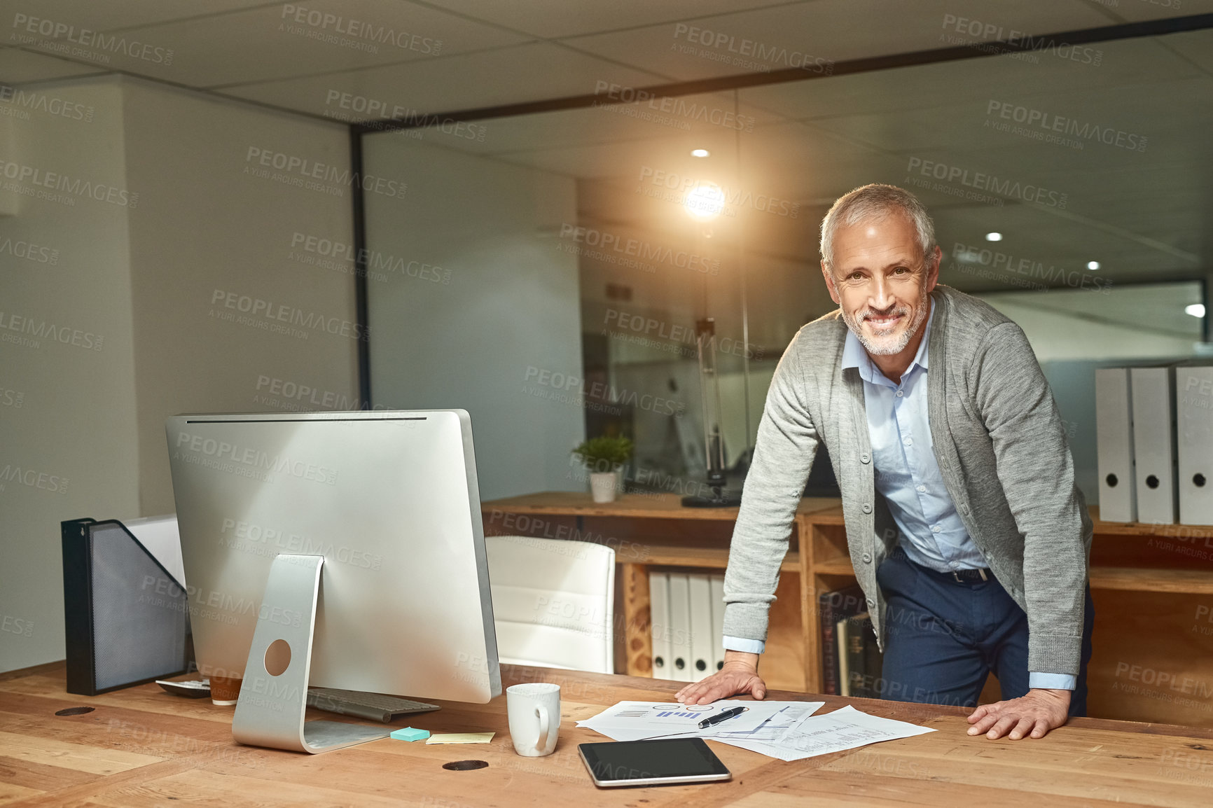 Buy stock photo Portrait of a mature businessman  standing by his desk in his office