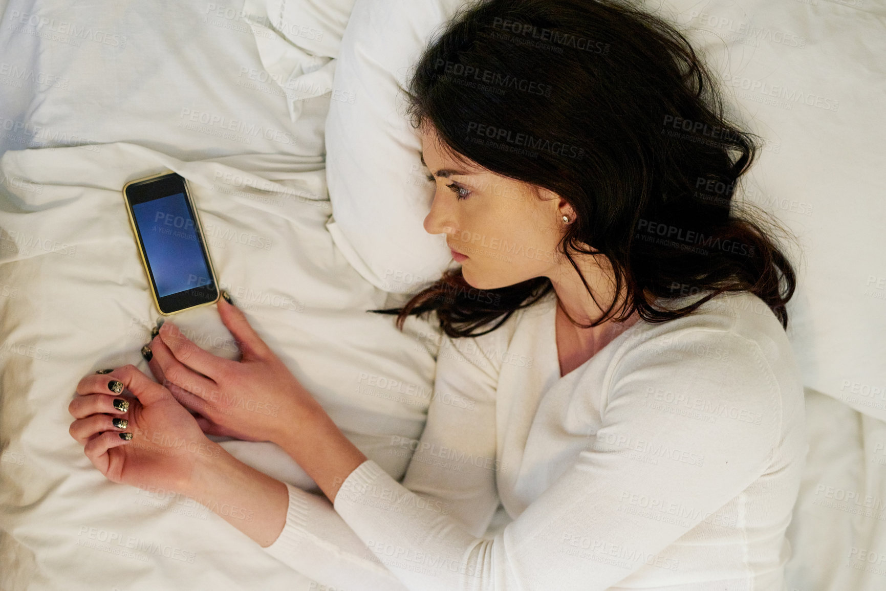 Buy stock photo Young woman, hand and smartphone in bed from break up with depression and anxiety staring at mobile. Sad, female person and staring at cellphone, waiting for response or message for mental health